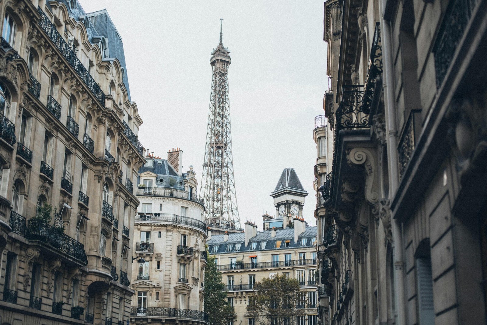 Scenic view of the Eiffel Tower framed by classic Parisian architecture on a charming street.